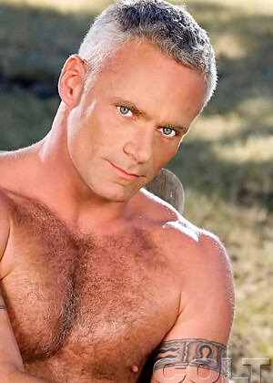 Hairy muscle man posing outdoors. Mature bodybuilder.