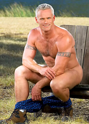 Hairy muscle man posing outdoors. Mature bodybuilder.