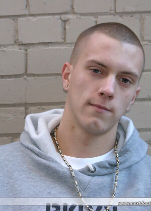 Shaved-headed stud Nick shows his inked body while masturbating on the bed