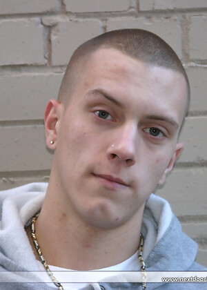Shaved-headed stud Nick shows his inked body while masturbating on the bed