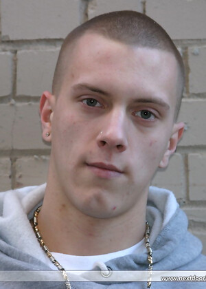 Shaved-headed stud Nick shows his inked body while masturbating on the bed