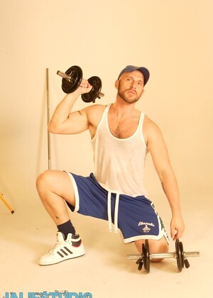 Strong hairy gay athlete Aitor Crash strips naked while lifting weights