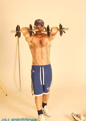 Strong hairy gay athlete Aitor Crash strips naked while lifting weights