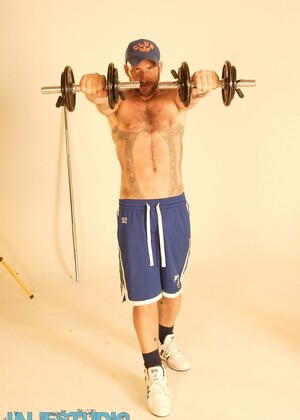 Strong hairy gay athlete Aitor Crash strips naked while lifting weights