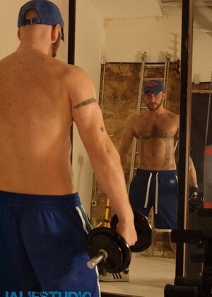 Strong hairy gay athlete Aitor Crash strips naked while lifting weights