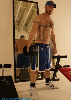 Strong hairy gay athlete Aitor Crash strips naked while lifting weights