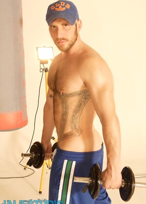 Strong hairy gay athlete Aitor Crash strips naked while lifting weights
