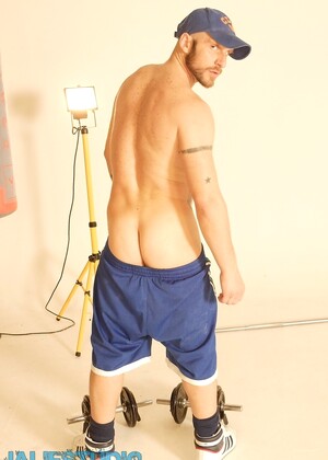 Strong hairy gay athlete Aitor Crash strips naked while lifting weights